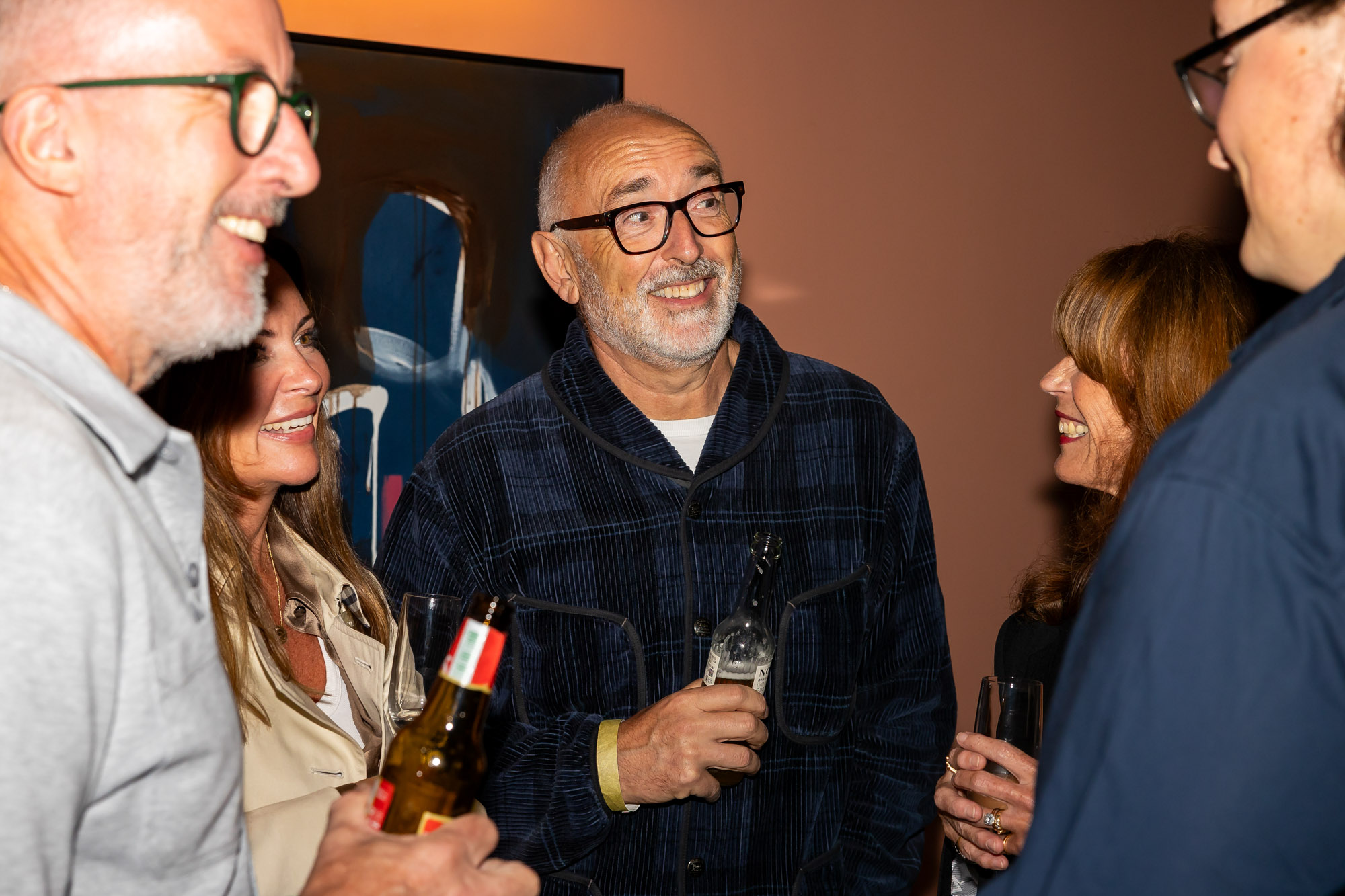 5 people talking and drinking together