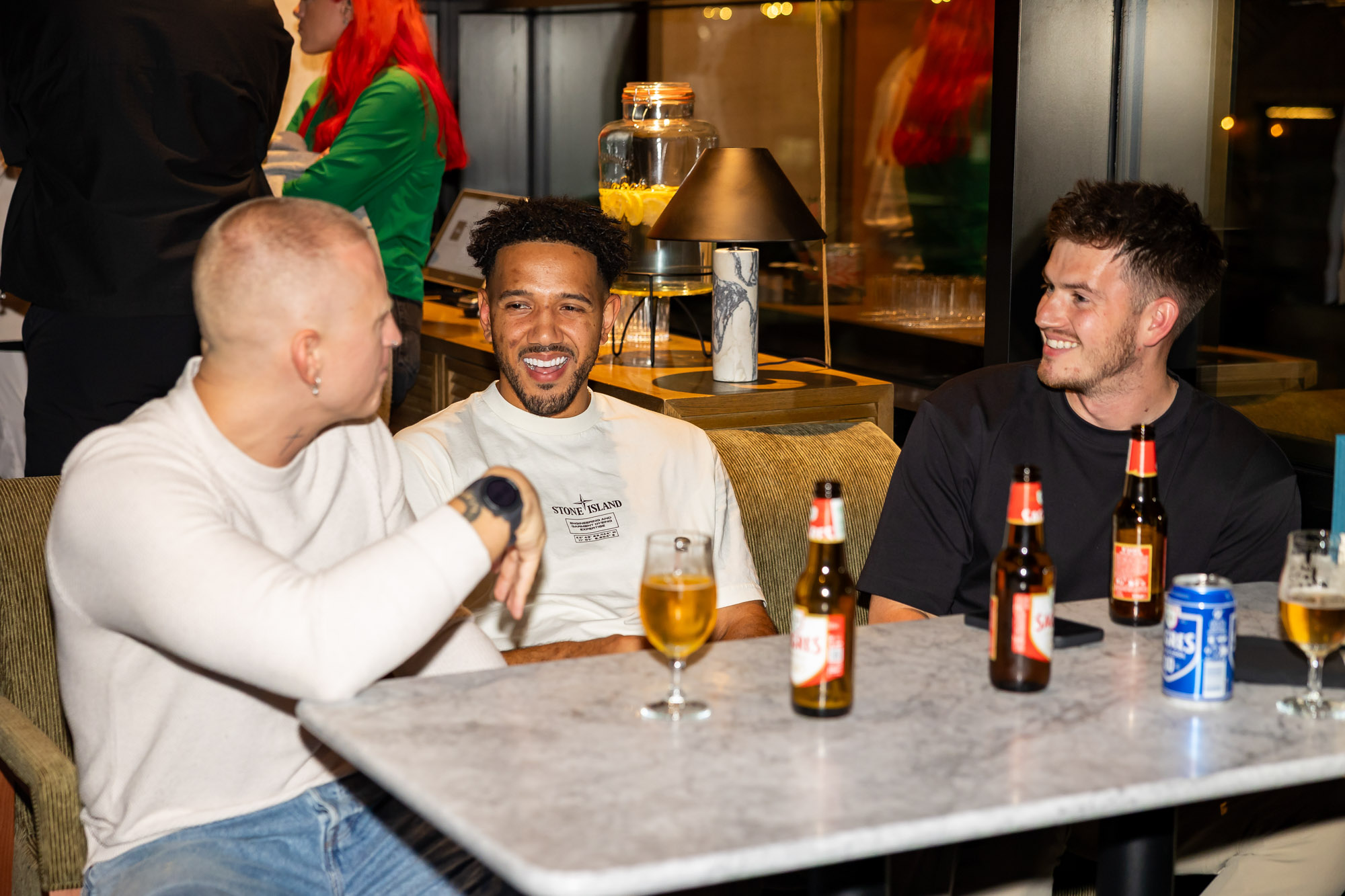 Three people sat at a table laughing